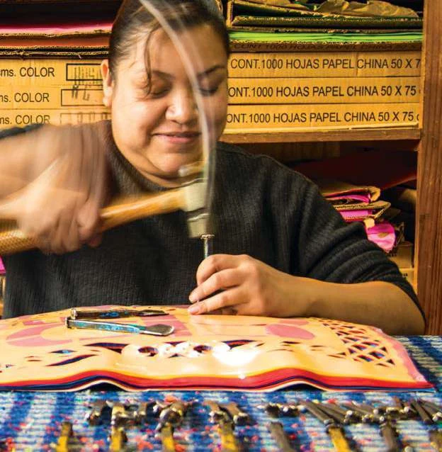 Artesana trabajando en una pieza de papel picado